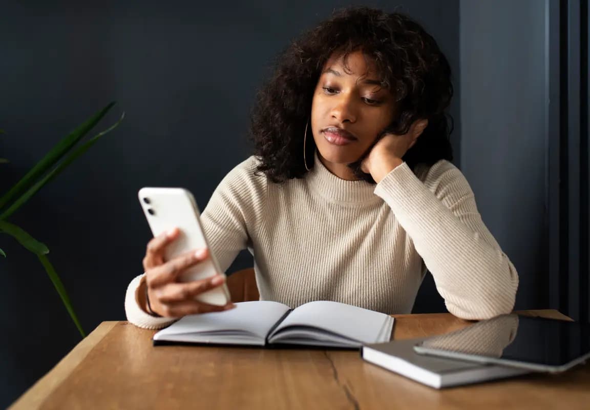 Femme réfléchissant à son avenir professionnel, consultant une voyance en ligne pour mieux orienter sa carrière.