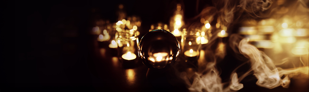 Boule de cristal entourée de bougies et de fumée, symbole de prédiction, de médiumnité et de perception des messages invisibles en voyance
