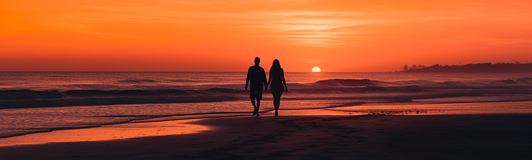 Couple marchant main dans la main sur une plage au coucher de soleil, symbole d’amour, de connexion profonde et d’harmonie dans les relations