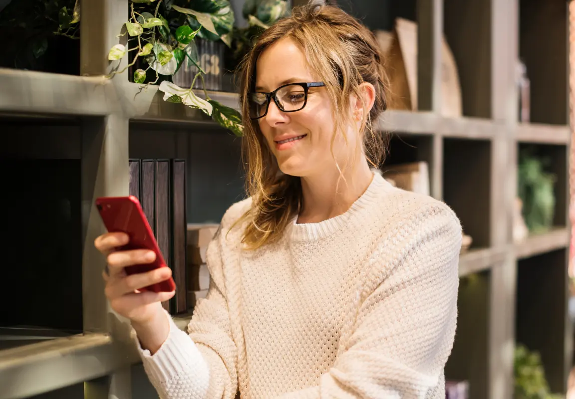 Femme consultant son horoscope sur smartphone, illustrant une analyse astrologique personnalisée et approfondie.